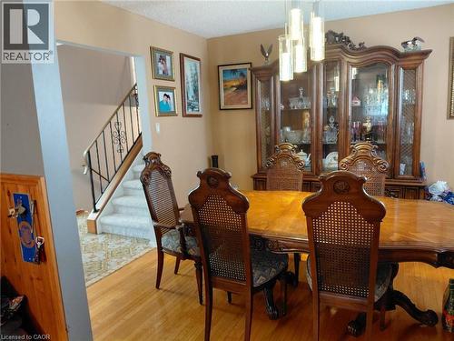 Wood-finish flooring, staircase with wrought iron railing, and a built-in display cabinet - 244 Guildwood Drive, Hamilton, ON 