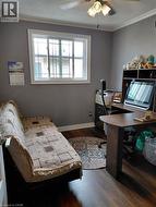 Wood-finish flooring with crown molding and a ceiling fan with integrated lighting - 