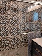 Tiled shower with patterned wall tiles, glass enclosure, and a built-in shower niche - 
