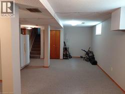 Spacious room with light gray walls, textured ceiling, and gray speckled carpet - 