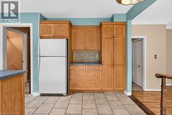 Light wood-finish cabinetry, tile flooring, built-in shelving, and a dark countertop - 