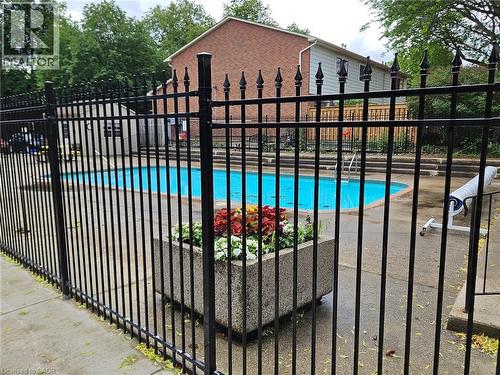 Pool area featuring a black metal fence, concrete planter with foliage, and a multi-level concrete deck - 1548 Newlands Crescent Unit# 14, Burlington, ON 