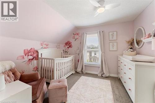 Carpeted room with sloped ceilings and a window featuring white blinds and neutral drapes - 17 Craigmiller Avenue, Hamilton, ON 