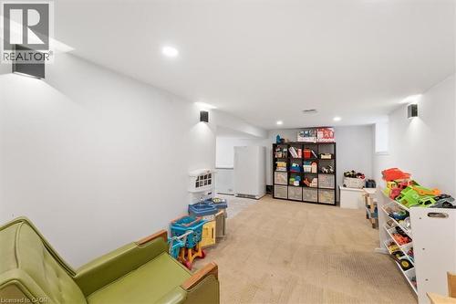 Spacious finished room featuring neutral carpeting, recessed lighting, and wall-mounted sconces - 17 Craigmiller Avenue, Hamilton, ON 