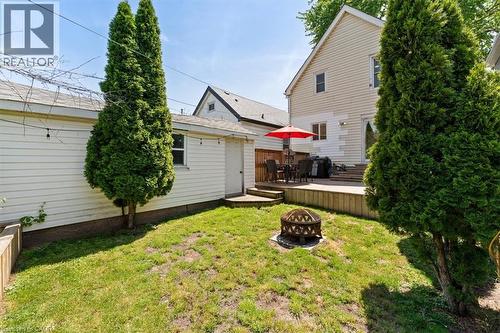 Expansive backyard featuring a manicured lawn, a fire pit, and mature trees - 17 Craigmiller Avenue, Hamilton, ON 