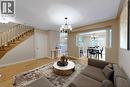 Wood-finish flooring throughout, spindle staircase, framed archway with decorative columns, and a dining area with sliding patio doors - 21 Eastview Gate Unit# 36, Brampton, ON 