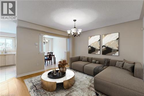 Open concept living area with wood-finish flooring, recessed lighting, and a chandelier - 21 Eastview Gate Unit# 36, Brampton, ON 