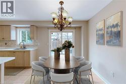 Kitchen area featuring light wood-finish cabinetry, white countertops, and a tiled backsplash - 