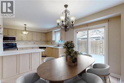 Kitchen with light wood-finish cabinetry, stainless steel appliances, and a mosaic tile backsplash - 21 Eastview Gate Unit# 36, Brampton, ON 