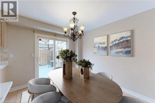 Dining area featuring a decorative chandelier, light wood-finish flooring, and a sliding glass door - 21 Eastview Gate Unit# 36, Brampton, ON 