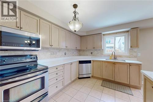Tile flooring, wood-finish cabinetry, stainless steel appliances, stone countertops, and a tile backsplash - 21 Eastview Gate Unit# 36, Brampton, ON 