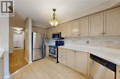 Kitchen featuring light-toned cabinetry, light countertops, and a tiled backsplash - 21 Eastview Gate Unit# 36, Brampton, ON 