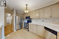 Kitchen featuring light-toned cabinetry, light countertops, and a tiled backsplash - 