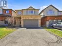 Traditional-style residence featuring a combination of brick and siding exterior, an attached garage, a covered front porch, and a paved driveway - 98 Willow Lane, Grimsby, ON 