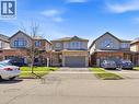 Two-story residence featuring a brick and siding exterior, an attached two-car garage, an asphalt driveway, a covered front entry, and a manicured front lawn - 98 Willow Lane, Grimsby, ON 