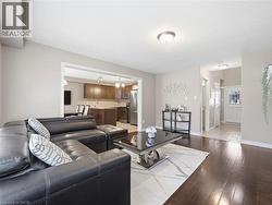 Open-concept living space featuring rich wood-finish flooring, recessed lighting, and a neutral color palette - 
