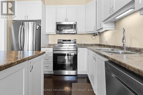 Modern white kitchen with stainless appliances - 223 Serra Ridge, Ottawa, ON 