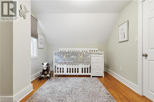 Wood-finish flooring, white trim, window with blinds, and a paneled door - 87 Strathcona Avenue, Brantford, ON 
