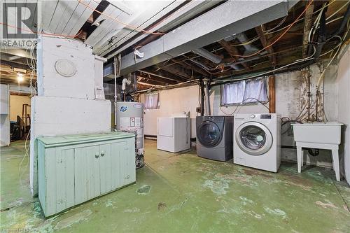 Basement utility space featuring a water heater, laundry appliances, and a utility sink - 87 Strathcona Avenue, Brantford, ON 