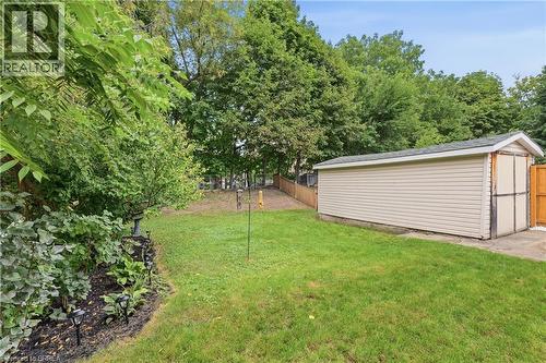 Expansive grassy yard with a detached utility shed featuring horizontal siding and a gable roof - 87 Strathcona Avenue, Brantford, ON 