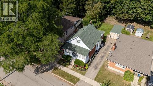 Gabled roofline, front porch, mature trees, driveway, and detached garage - 87 Strathcona Avenue, Brantford, ON 