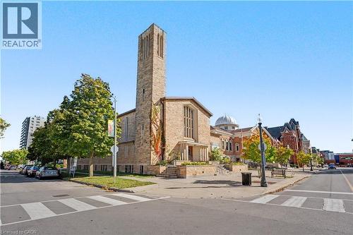 Stone-clad building with prominent bell tower and classical dome architecture - 97 Wellington Street, Brantford, ON 