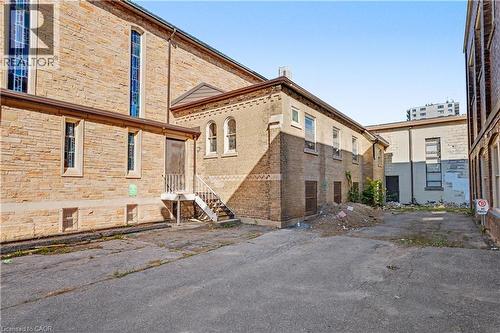 Multi-level brick exterior with arched windows, stained glass features, and an exterior staircase - 97 Wellington Street, Brantford, ON 