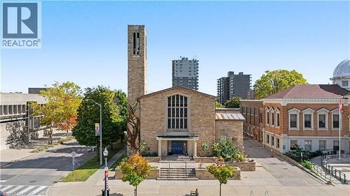 Stone masonry facade with prominent bell tower and large multi-pane windows - 97 Wellington Street, Brantford, ON 