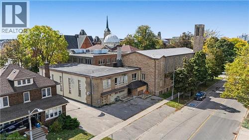 Brick exterior with multiple rooflines and a prominent bell tower - 97 Wellington Street, Brantford, ON 