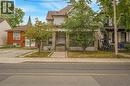 Property featuring a stone and siding exterior, front entry with transom window, and a mature tree in the front yard - 211 Wentworth Street N, Hamilton, ON 