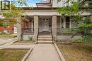 Stone-clad porch columns, concrete steps with metal railings, and a prominent front entrance - 211 Wentworth Street N, Hamilton, ON 