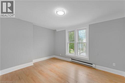 Wood-finish flooring, crown molding, double-pane windows, and a flush-mount ceiling light - 211 Wentworth Street N, Hamilton, ON 