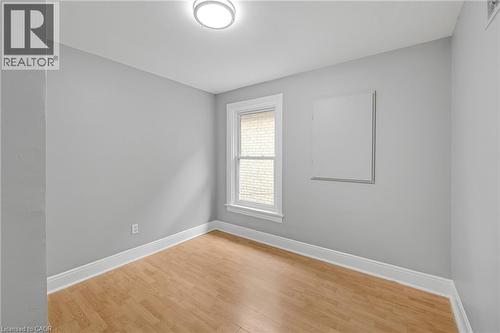 Wood-finish flooring, white trim, and a window with a white frame - 211 Wentworth Street N, Hamilton, ON 