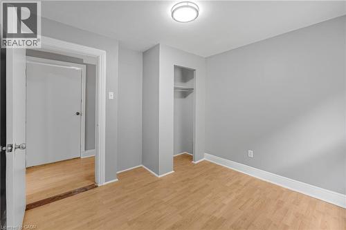 Recessed closet with shelving and hanging rod, wood-finish flooring, flush mount ceiling light fixture, and freshly painted gray walls - 211 Wentworth Street N, Hamilton, ON 