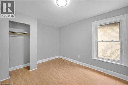 Recessed closet with a clothes rod, wood-finish flooring, single window, and a ceiling-mounted light fixture - 211 Wentworth Street N, Hamilton, ON 