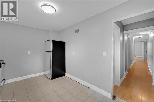 Kitchen area featuring neutral wall paint, tiled flooring, and a flush-mount ceiling light - 211 Wentworth Street N, Hamilton, ON 
