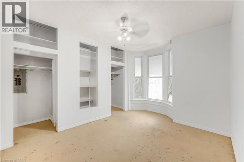 Bay window with multiple panes, built-in shelving, closet with hanging rod, and ceiling fan - 211 Wentworth Street N, Hamilton, ON 