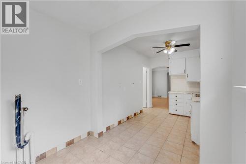 Tiled flooring extending into kitchen area, white walls, and an arched doorway - 211 Wentworth Street N, Hamilton, ON 