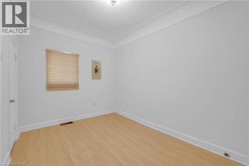 Light wood-finish flooring, white walls, and a window with blinds - 211 Wentworth Street N, Hamilton, ON 