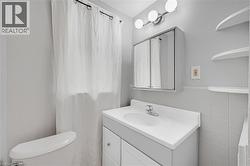 Vanity with an integrated sink and chrome faucet, medicine cabinet with mirrored doors, and wall-mounted spherical light fixture - 