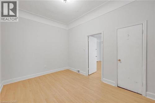 Light wood-finish flooring with white baseboards - 211 Wentworth Street N, Hamilton, ON 