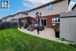 Expansive backyard featuring a manicured lawn, concrete patio, and a wood pergola - 