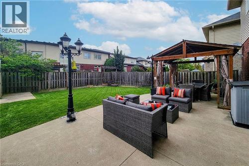 Expansive concrete patio with a wooden pergola structure and a lamp post - 214 Cloverleaf Drive, Ancaster, ON 