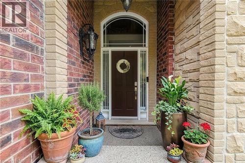 Brick and stone exterior with an arched entryway - 214 Cloverleaf Drive, Ancaster, ON 