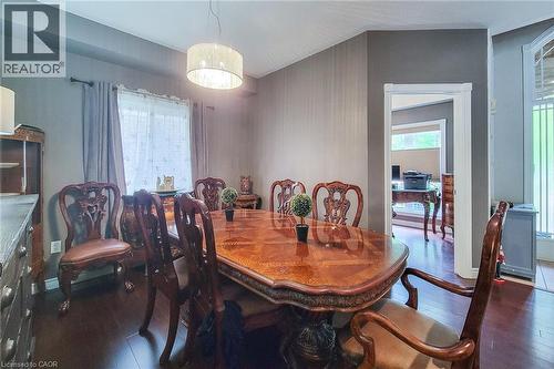 Wood-finish flooring with a drum pendant light fixture, a window with drapery, and a wide doorway - 214 Cloverleaf Drive, Ancaster, ON 