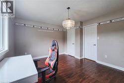 Hardwood-style flooring, white trim, recessed lighting, and a crystal chandelier - 