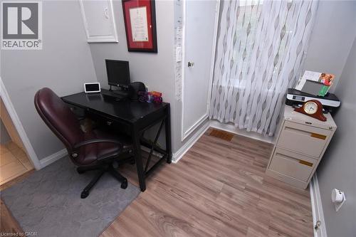 Wood-finish flooring with white trim, light gray painted walls, and a window with sheer curtains - 154 Ewen Road, Hamilton, ON 