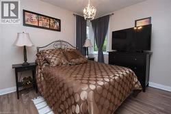 Recessed window, wood-finish flooring, and a decorative chandelier - 