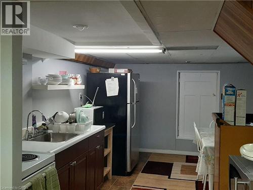 Kitchenette featuring a stainless steel refrigerator, electric range, and wood-finish cabinetry - 154 Ewen Road, Hamilton, ON 