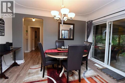 Dining area featuring wood-finish flooring, a contemporary chandelier, and a sliding glass door - 154 Ewen Road, Hamilton, ON 